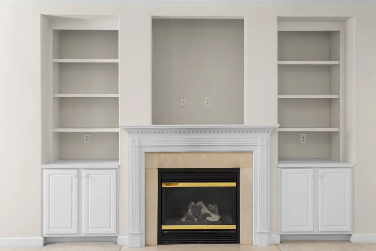 Luxurious white interior with built-in shelves surrounding a central fireplace