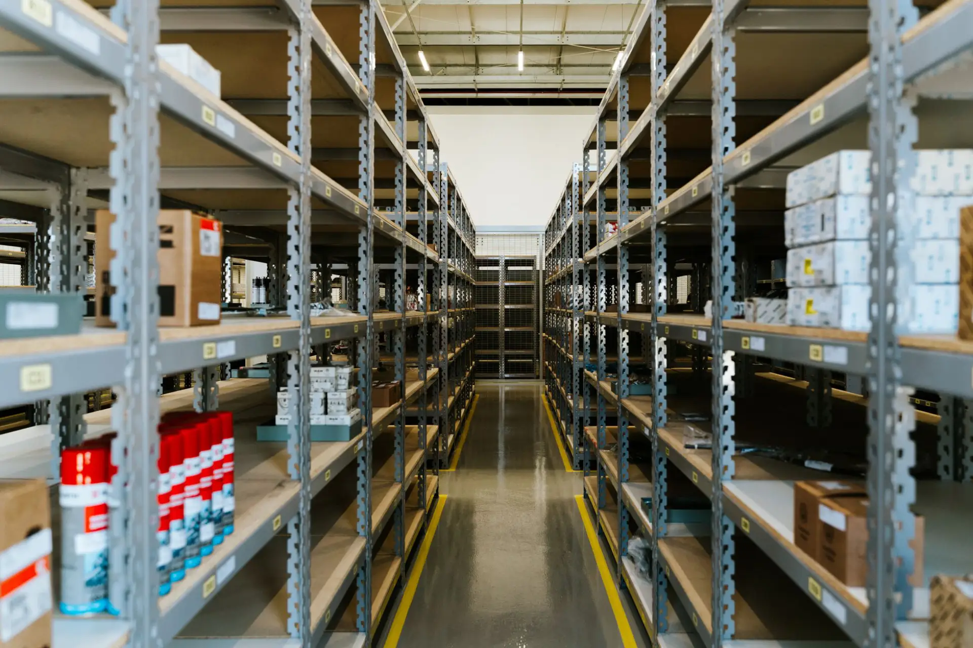 Organized industrial storage aisle with metal shelving and labeled inventory