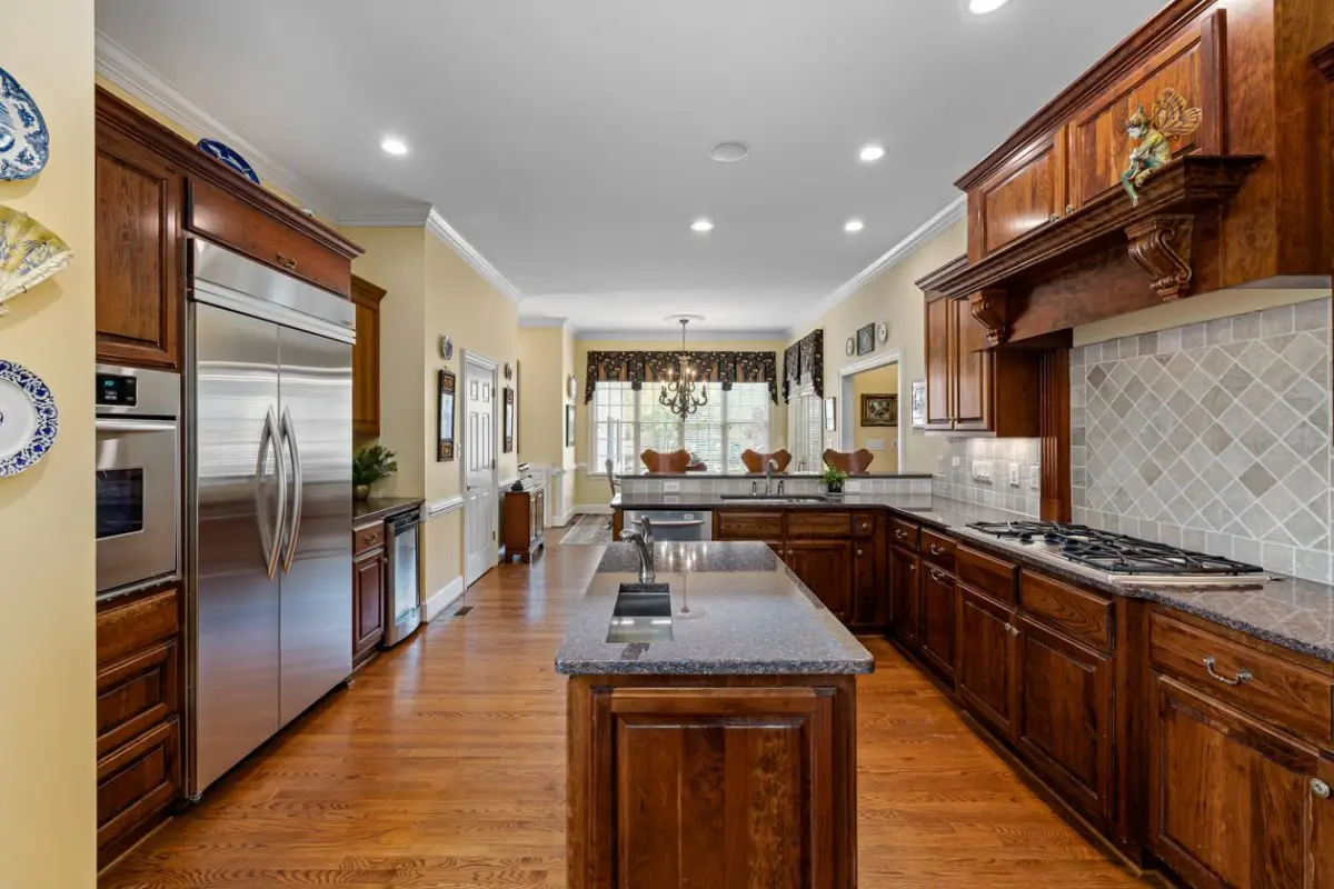 Dark stained wood kitchen cabinets with granite countertops showing wood species and finish detail