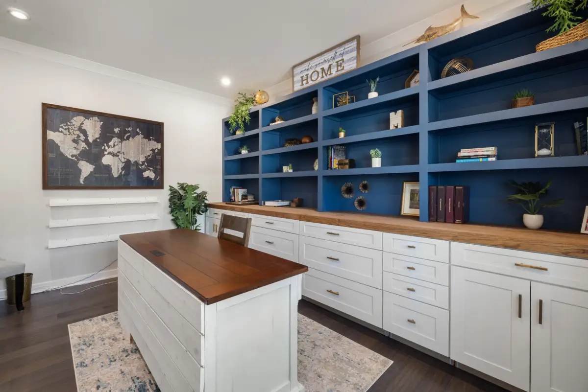 Modern home office built-in shelving with a wooden desk and storage
