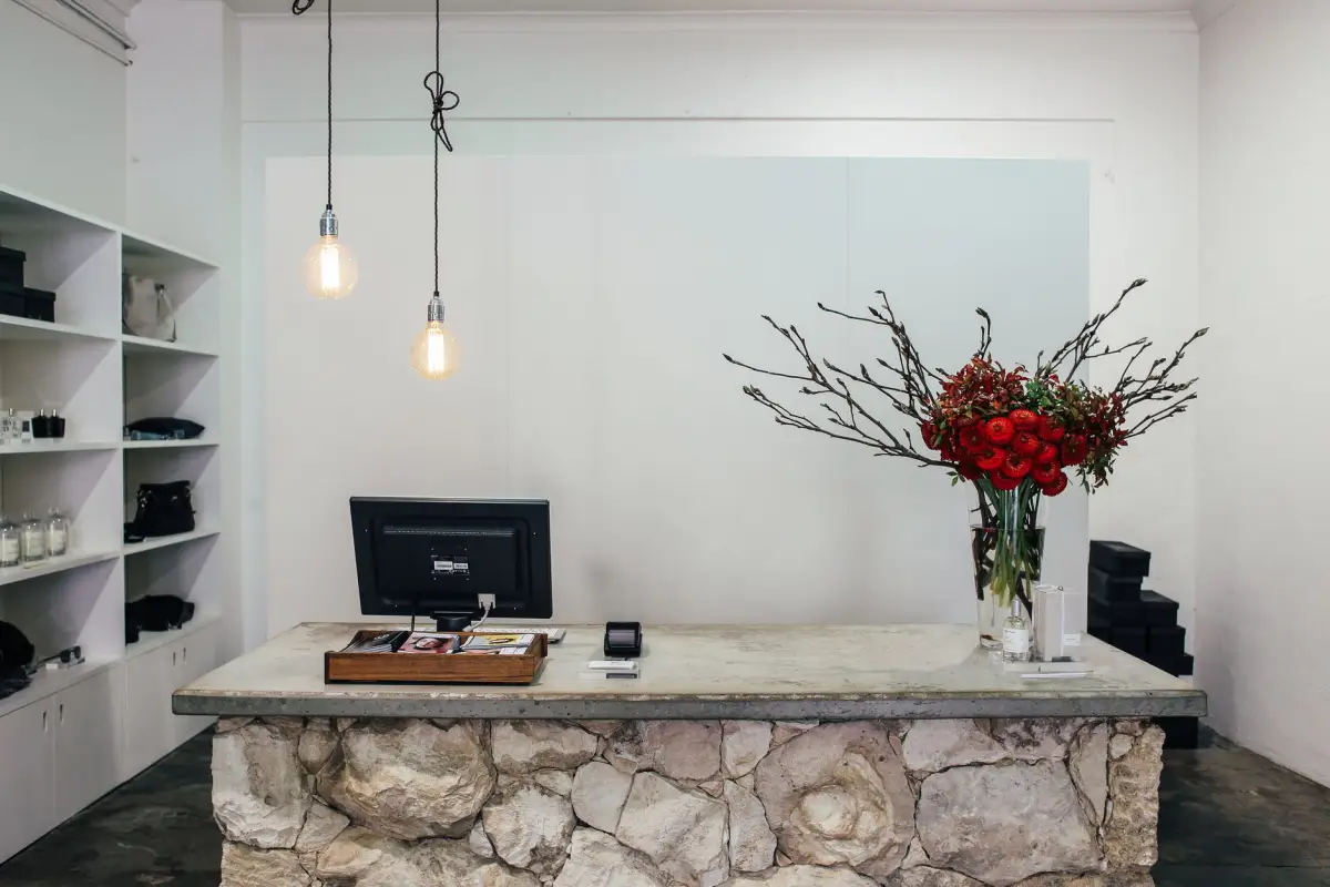 Stone checkout counter with white display shelving in a boutique store